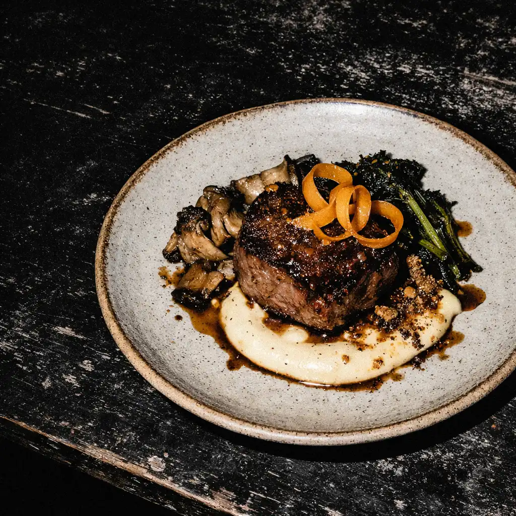 A plated dish on a worn dark restaurant table