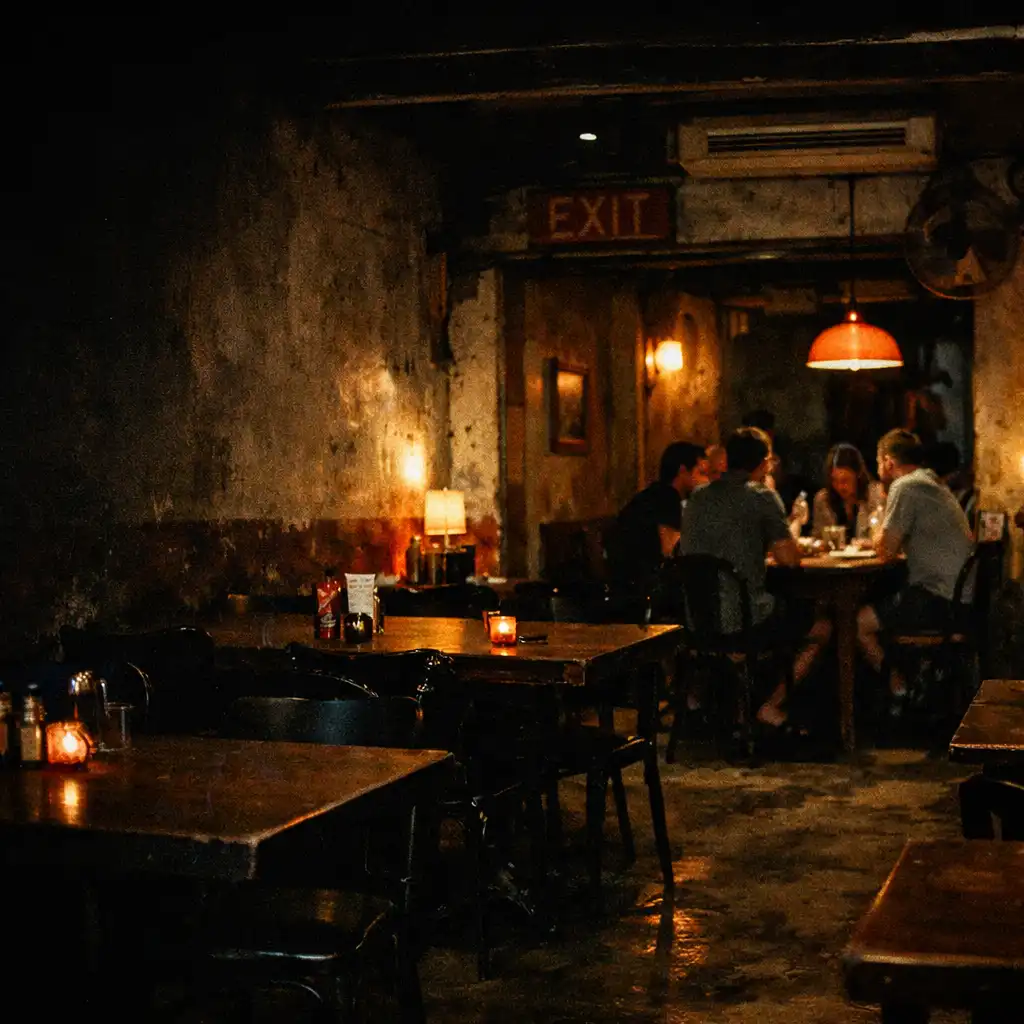 Flash-lit view across dark restaurant tables in TASTE VERANDA's after-hours interior